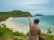 Asian fatty backpacker stand on view point on top of the island with idyllice beach ocean and blue sky in vacation time