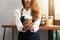 Asian female barista hold a cup of coffee serving to her customer with smile surrounded with bar counter.