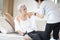 Asian female caregiver taking care of helping elderly patient get dressed,wearing clothes or undressing for senior mother,