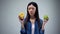Asian female choosing between sweet greasy donut and juicy green apple, decision