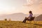 Asian female in cowboy fashion style relax her vacation with cows family there pasture space and colourful nature background