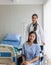 Asian female doctor cheered on a female patient in a wheelchair in her room