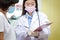 An Asian female doctor explains to his wife the treatment information of an African-American male patient.