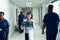 Asian female doctor studying x-ray photo standing in busy hospital corridor