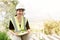 Asian female engineer Wearing a green safety shirt Sitting in the construction area