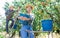 Asian female farmer carrying bucket with pears