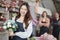 Asian female florist worker stands in front of a team in colorful flower shop.