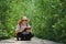 Asian female forester sitting on walkway and taking note in mangrove forest at natural parkland