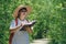 Asian female forester taking notes on walkway in mangrove forest at natural parkland