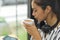 Asian female freelancer sipping tea, relaxed after a long work at cafe