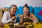 Asian female friends having Japanese sushi for lunch - happy and attractive woman and her girlfriend eating sushi rolls at home