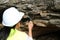 Asian female geologist researcher analyzing rocks with a magnifying glass in a natural park. Exploration Geologist in the Field.