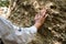 Asian female geologist researcher touches rocks by hand to analyze surface in Mae Wang Natural Park, Thailand. Exploration