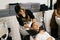 An Asian female hairdresser begins to wash the hair of a woman in a sink in a hair salon.