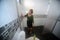 Asian female maid or housekeeper cleaning on toilet wall.