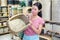 Asian female standing with basket in shop