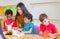 Asian female teacher teaching diversity kids reading book in classroom,Kindergarten pre school concept.