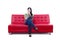 Asian female thinking on red sofa - isolated