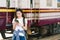 Asian female traveler, beautiful woman using map or social media check-in on smartphone at train station railway platform