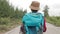 Asian female traveler in hat and backpack walking on road Enjoy nature tourism.