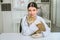 asian female veterinarian holding a cute cat on a diagnosis table in clinic