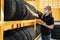 Asian female worker wear a mask to prevent the spread of corona virus or COVID-19 checking the stock of car tires at warehouse and