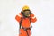 An Asian firefighters are wearing orange fire protection uniform mask and helmet on white background.