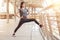 asian fitness young woman stretching leg on a rail bridge workout exercising on street in urban city . runner sport girl warm up