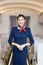 Asian flight attendant posing with smile at middle of the aisle inside aircraft passenger seat on the background