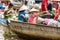 Asian floating markets on Mekong River with boats crammed together full of produce and woman in conical hat pointing