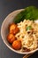 Asian Food concept homemade oriental egg noodles and spicy meatballs in ceramic bowl on black background