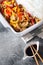 Asian food: fried chicken with tricolor bell peppers and rice vermicelli