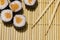 Asian food photography sushi maki rolls with salmon raw fish on traditional wooden carpet background with sticks