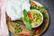 Asian food on the table - Thai food green curry chicken on soup bowl and thai rice noodles vermicelli with ingredient herb