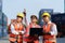 Asian foreman holding laptop and explaining the various operations in the container depot terminal to worker