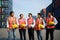 Asian foreman and staff resting and talking together in the container depot terminal after work in evening