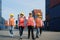 Asian foreman walking and explaining the various operations in the container depot terminal with four new trainees worker