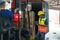 Asian forklift driver loading a shipping cargo container with a full pallet with boxes in logistics port terminal. Asian warehouse