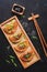 Asian fried dumplings with green onions and sesame, soy sauce, chopsticks. Black stone background, top view, flat lay