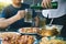 Asian friends are helping to pour beer into the bottle of his partner and have fun together in celebration