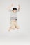 Asian funny child boy jumping on gray background