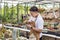 Asian gardener is working inside the greenhouse full of cactus plants collection while propagating by flower pollination for seed