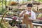 Asian gardener is working inside the greenhouse full of cactus plants collection while propagating by flower pollination for seed