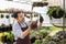 Asian gardener is working inside the greenhouse full of succulent plants collection while propagating by leaf cutting method for