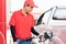 Asian gas station worker man filling high energy power fuel in auto car tank in petrol station, commercial service for benzine,