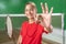 Asian girl badminton player with okay hand gesture holding racket