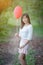 Asian girl with balloons plays in a field