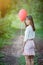 Asian girl with balloons plays in a field