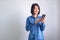 Asian girl with blue shirt left hand holding phone