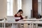 Asian girl college student in glasses reading materials while preparing for test or exam in library